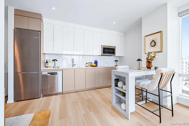 a kitchen with stainless steel appliances a refrigerator sink and white cabinets