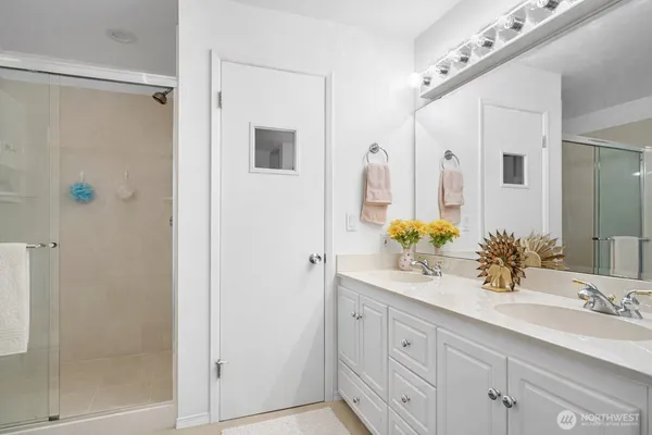 a bathroom with a granite countertop sink a mirror and a shower