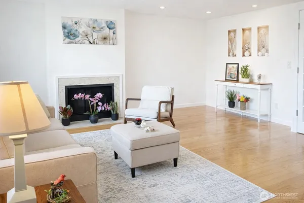 a living room with furniture and a fireplace with wooden floor
