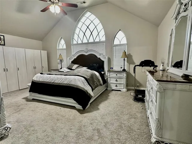 a spacious bedroom with a bed and a chandelier
