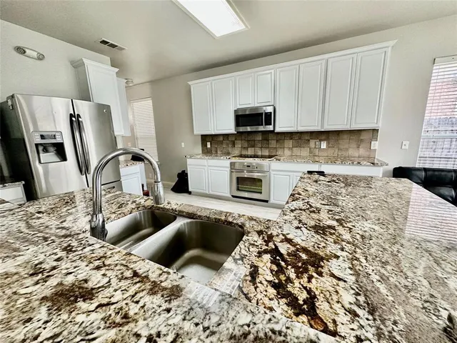 a kitchen with sink a stove and refrigerator