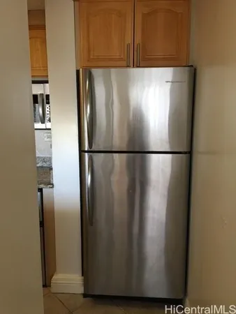 a close view of a refrigerator in kitchen with stainless steel appliances wooden floor