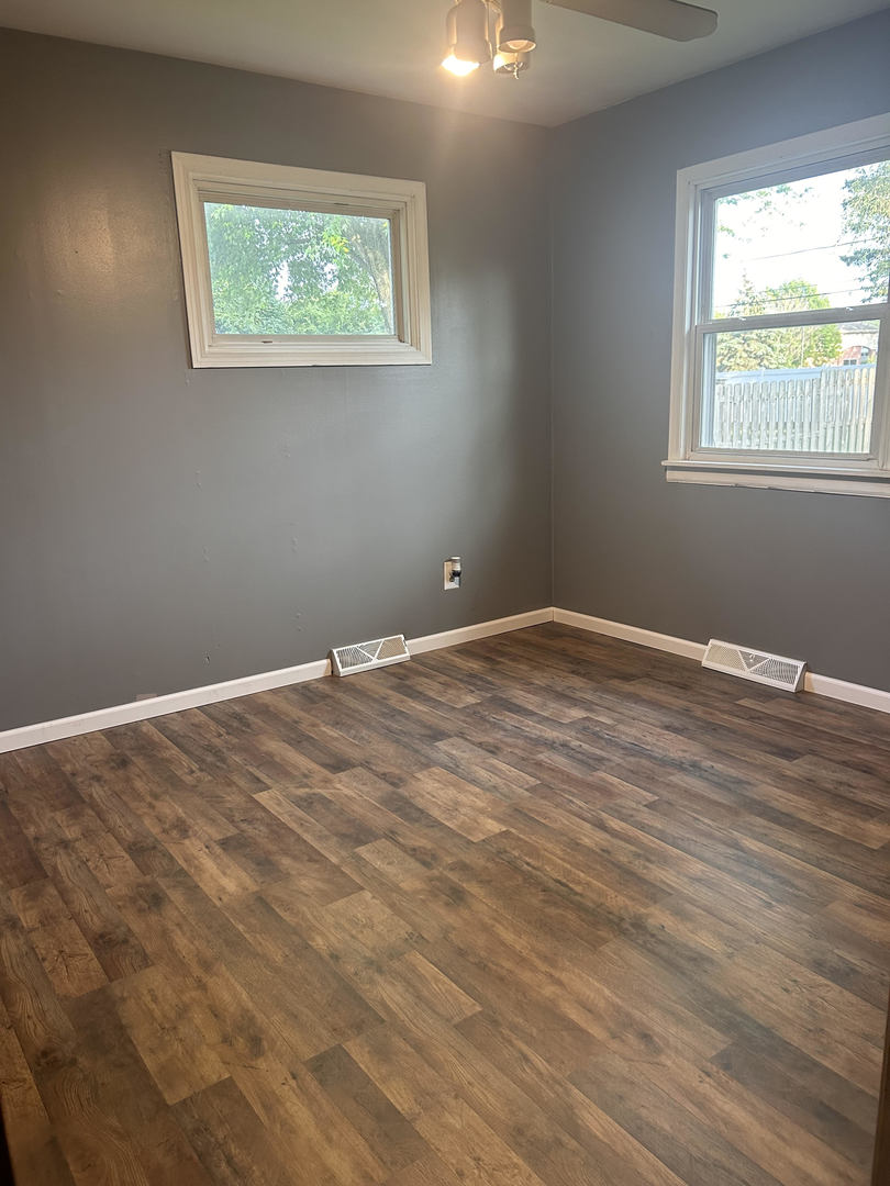 320 Hillside Road New Lenox, IL 60451 - Photo 8 of 14 a view of an empty room with wooden floor and a window