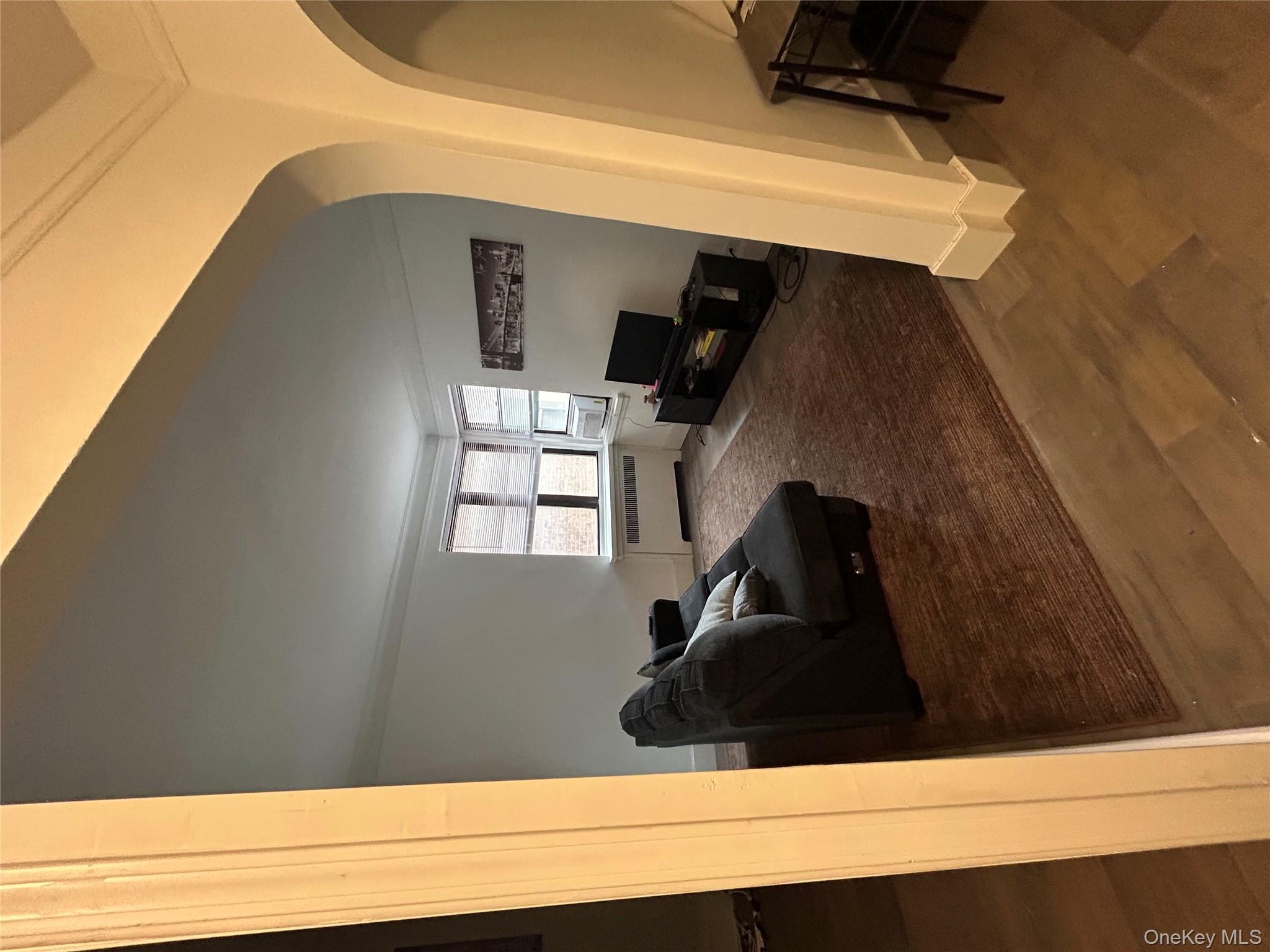 3000 Valentine Avenue, Unit 3E Bronx, NY 10458 - Photo 3 of 7 a living room with furniture and a mirror