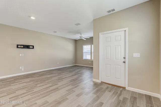 a view of an empty room with wooden floor