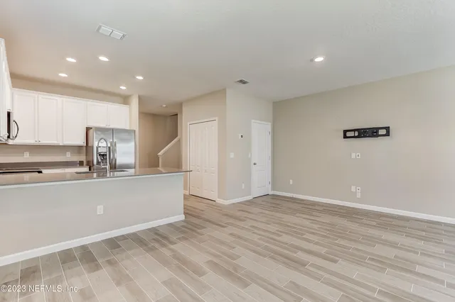 a living room with stainless steel appliances kitchen island hardwood floor sink and stove