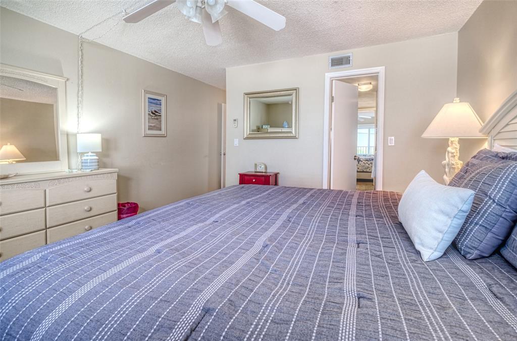 60 Gulf Boulevard, Unit 204 Indian Rocks Beach, FL 33785 - Photo 20 of 45 a bedroom with a large bed and a chandelier