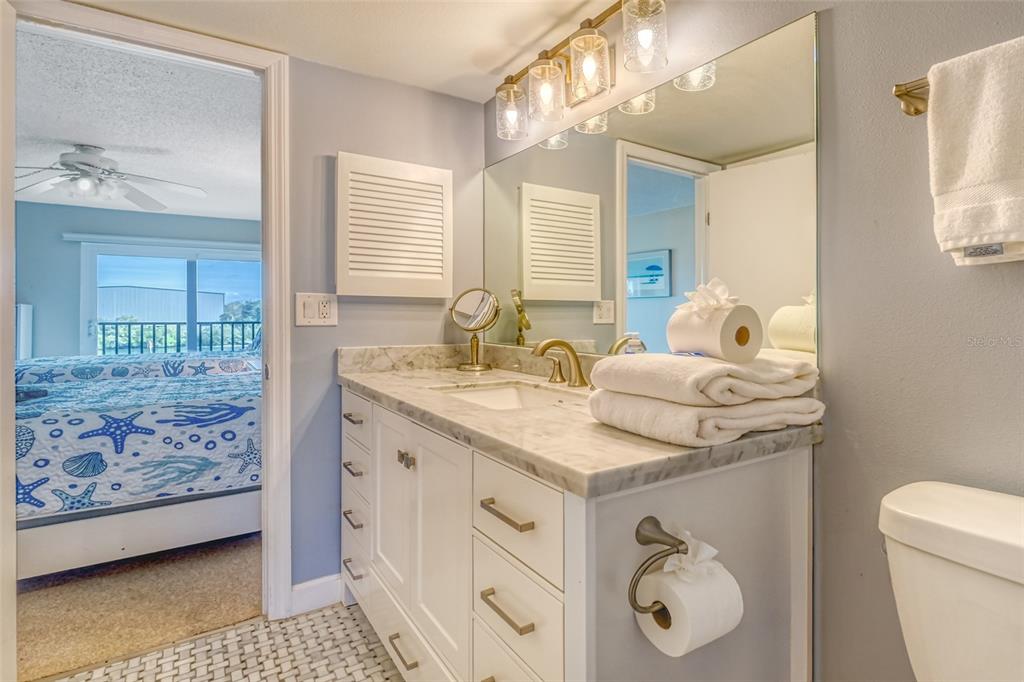 60 Gulf Boulevard, Unit 204 Indian Rocks Beach, FL 33785 - Photo 22 of 45 a bathroom with a granite countertop sink and a mirror