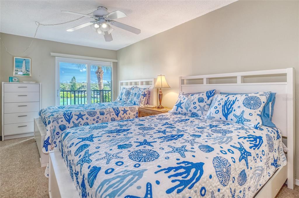 60 Gulf Boulevard, Unit 204 Indian Rocks Beach, FL 33785 - Photo 25 of 45 a bed sitting in a bedroom next to a window with a chandelier