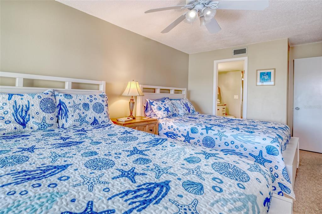 60 Gulf Boulevard, Unit 204 Indian Rocks Beach, FL 33785 - Photo 26 of 45 a bedroom with a bed and a chandelier