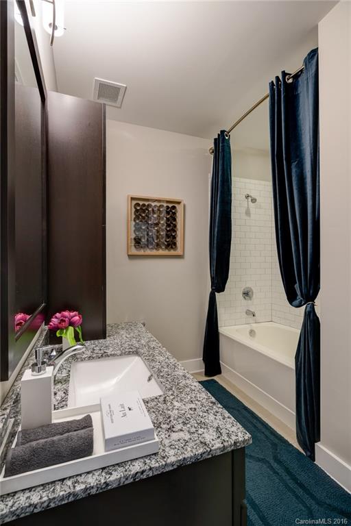 1440 Harding Place, Unit 446 Charlotte, NC 28204 - Photo 13 of 19 a bathroom with a granite countertop sink and a mirror