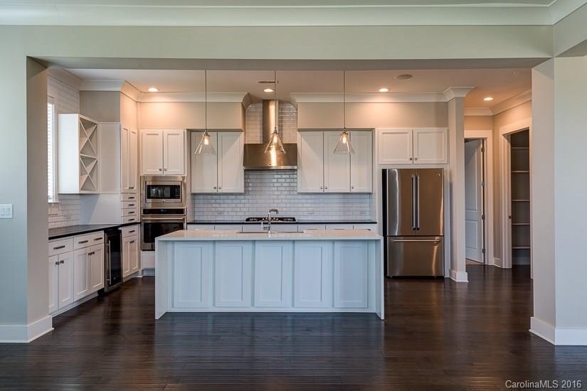 1440 Harding Place, Unit 446 Charlotte, NC 28204 - Photo 7 of 19 a large kitchen with stainless steel appliances a refrigerator and wooden floor