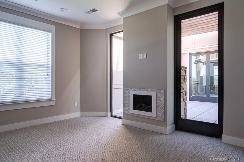 1440 Harding Place, Unit 446 Charlotte, NC 28204 - Photo 10 of 19 a view of an empty room with a fireplace and a window