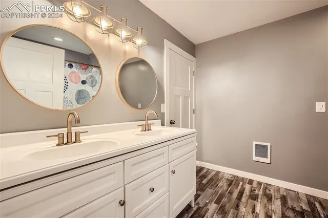 a bathroom with a double vanity sink and a mirror