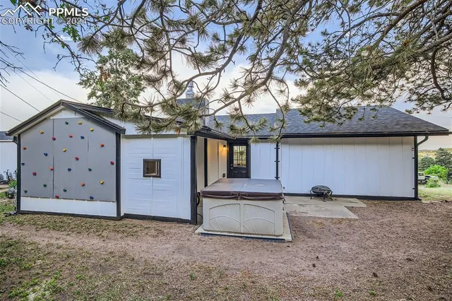 a view of a house with a large tree and wooden fence