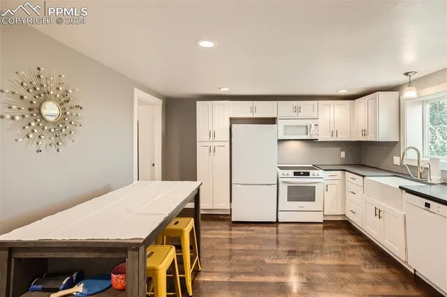 a kitchen with a sink a stove a refrigerator and white cabinets