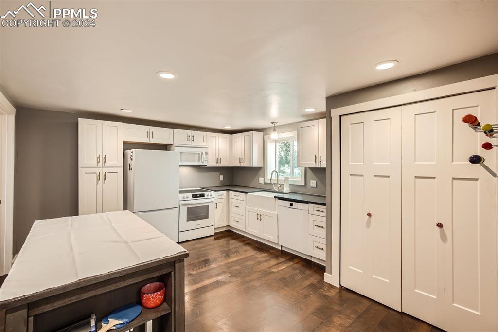 118 Hillside Road Palmer Lake, CO 80133 - Photo 9 of 25 a kitchen with white cabinets and stainless steel appliances