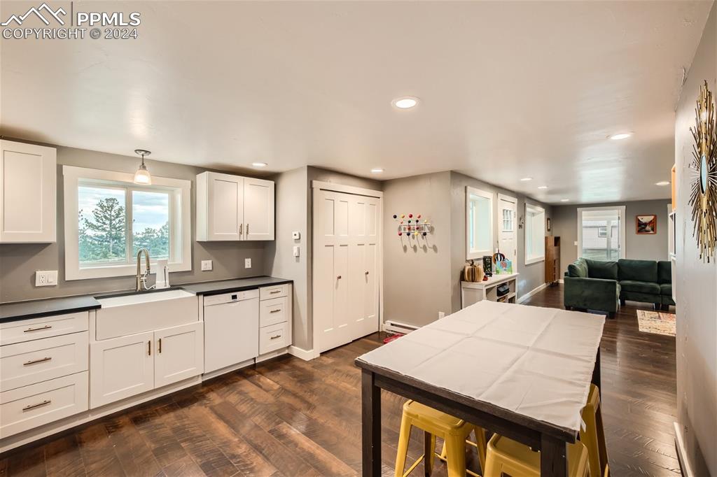118 Hillside Road Palmer Lake, CO 80133 - Photo 10 of 25 a large kitchen with kitchen island a sink a stove a dining table and chairs