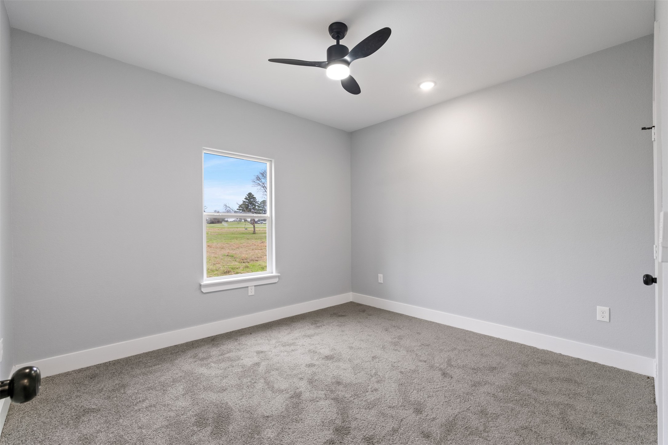 7 Meadowview Drive Trinity, TX 75862 - Photo 19 of 32 an empty room with a window and a ceiling fan