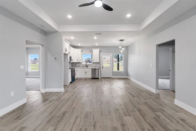 a view of kitchen with refrigerator stove and wooden floor