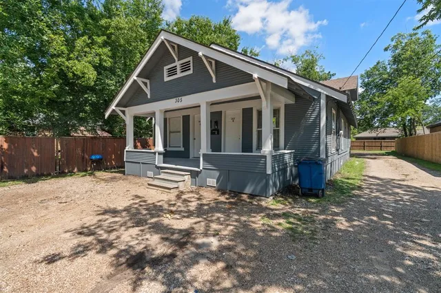 a view of a house with a yard and wooden fence