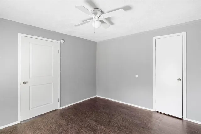 an empty room with fan and windows