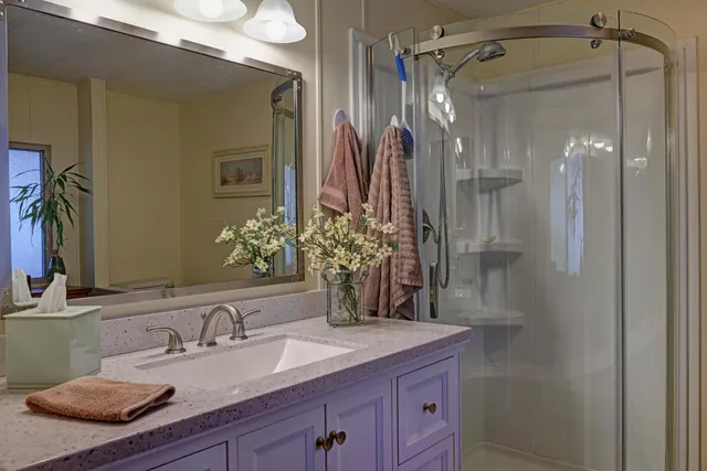 a bathroom with a granite countertop sink and a mirror