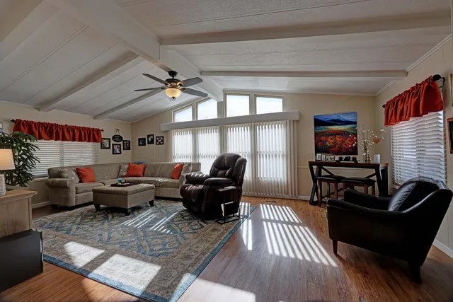 a living room with furniture floor to ceiling window and a flat screen tv
