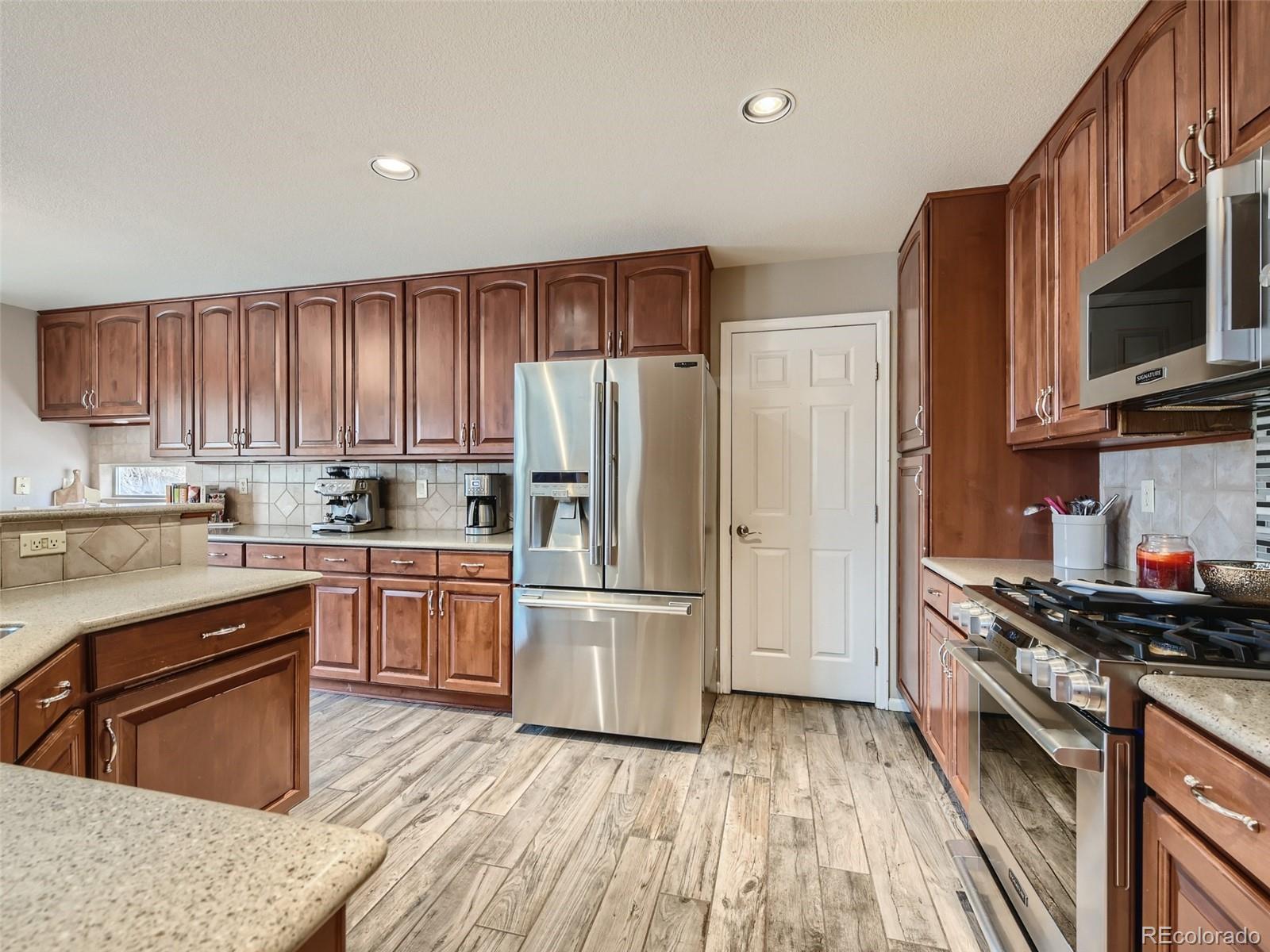 9724 Chanteclair Circle Highlands Ranch, CO 80126 - Photo 11 of 28 a kitchen with stainless steel appliances granite countertop a refrigerator stove microwave and sink
