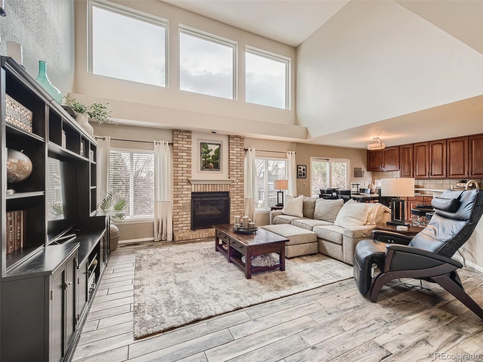 9724 Chanteclair Circle Highlands Ranch, CO 80126 - Photo 13 of 28 a living room with furniture a fireplace and a flat screen tv