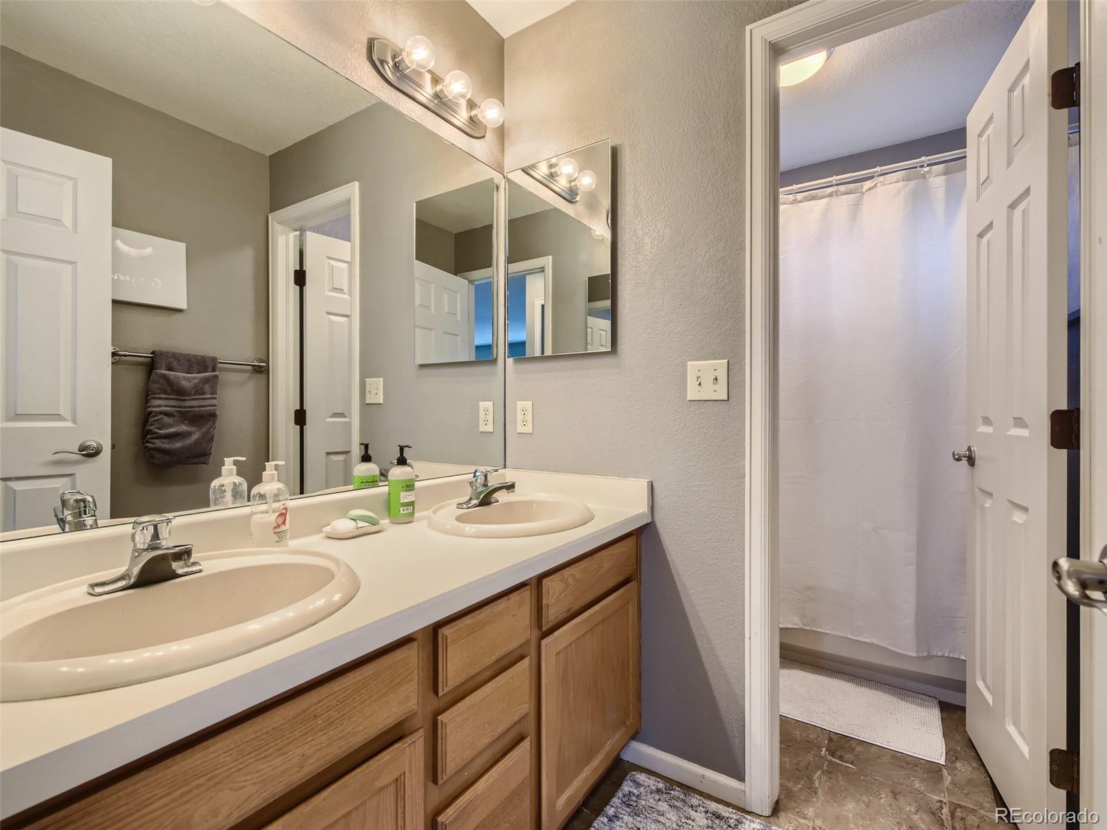 9724 Chanteclair Circle Highlands Ranch, CO 80126 - Photo 21 of 28 a bathroom with a double vanity sink and a mirror