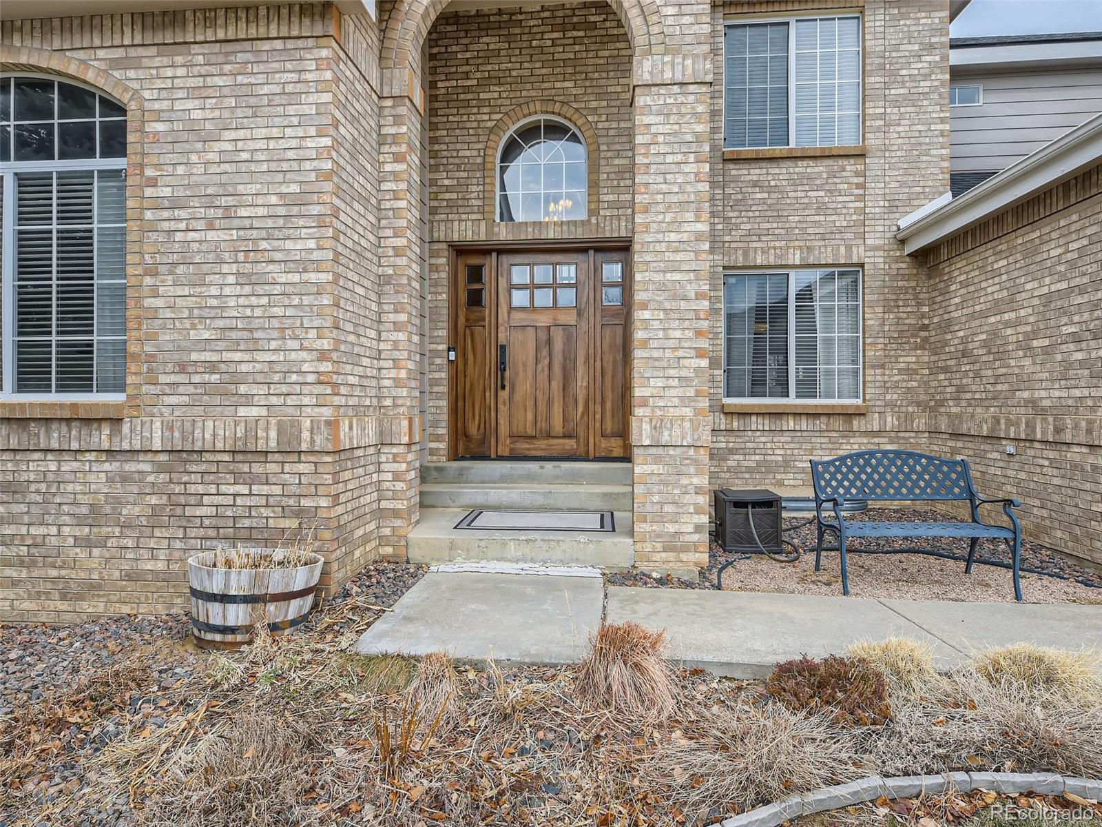 9724 Chanteclair Circle Highlands Ranch, CO 80126 - Photo 3 of 28 a view of a brick house with many windows