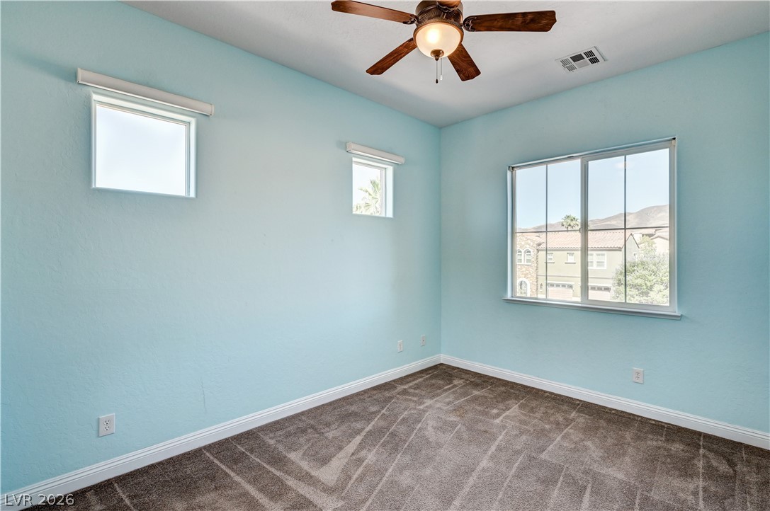 2793 Rosenhearty Drive Henderson, NV 89044 - Photo 47 of 85 This naturally illuminated bedroom offers comfort with soft carpeting and a ceiling fan.