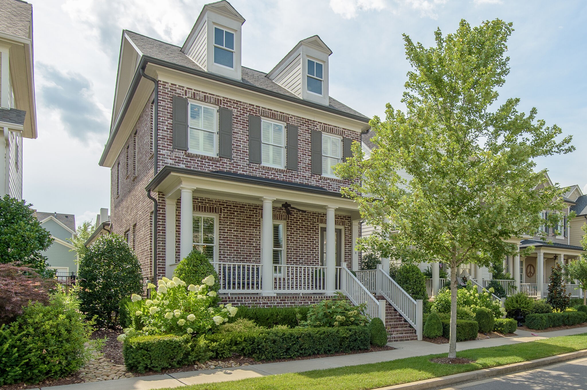 a front view of a house with trees and plants