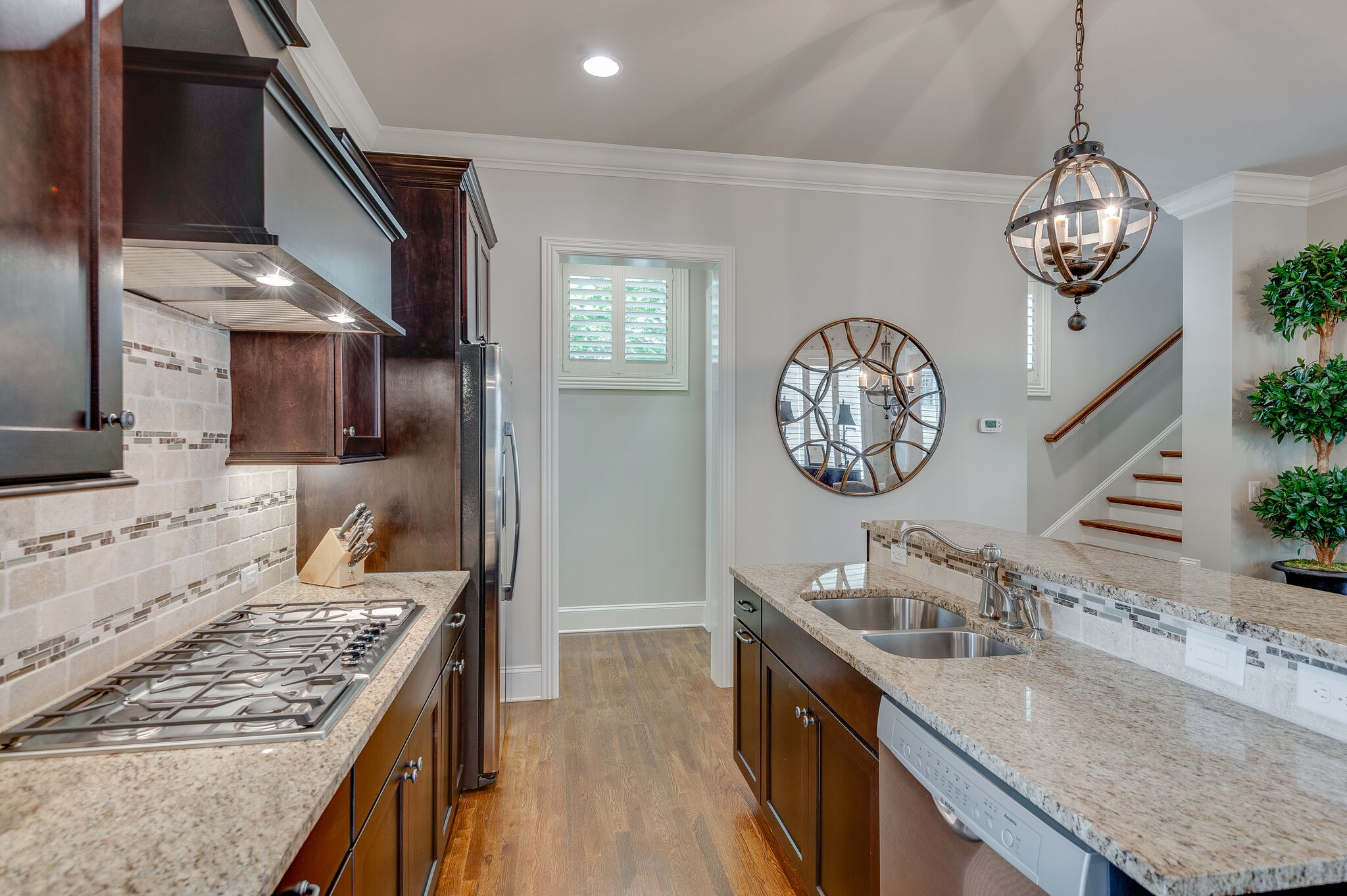 324 Fitzgerald Street Franklin, TN 37064 - Photo 11 of 39 a kitchen with granite countertop a sink a stove top oven a clock and cabinets
