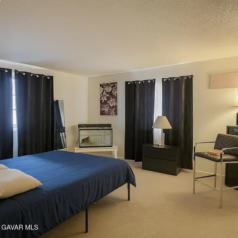a bedroom with a bed closet and a flat tv screen