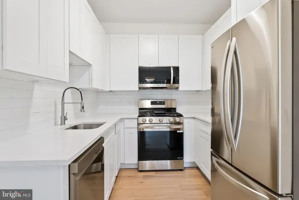 a kitchen with stainless steel appliances granite countertop a refrigerator stove and sink