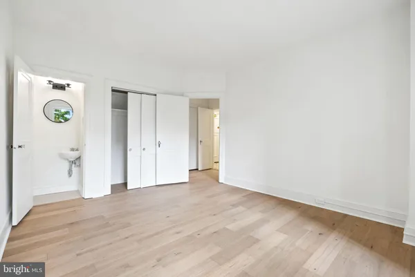 a view of an empty room with wooden floor and windows