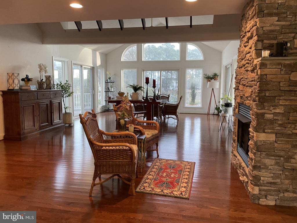 17451 Poplar Street Piney Point, MD 20674 - Photo 10 of 27 a dining room with wooden floor a chandelier a glass table and chairs