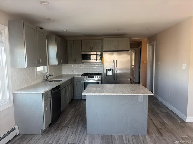 a kitchen with stainless steel appliances granite countertop a sink a stove and a refrigerator