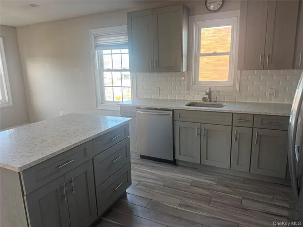 a kitchen with a sink cabinets appliances and a window