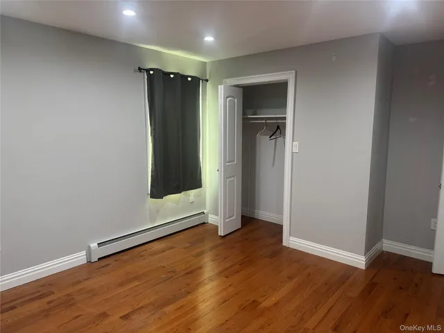 an empty room with wooden floor and closet