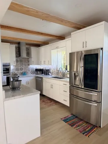 a kitchen with stainless steel appliances a refrigerator sink and microwave
