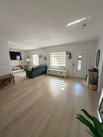 a view of empty room with wooden floor and windows
