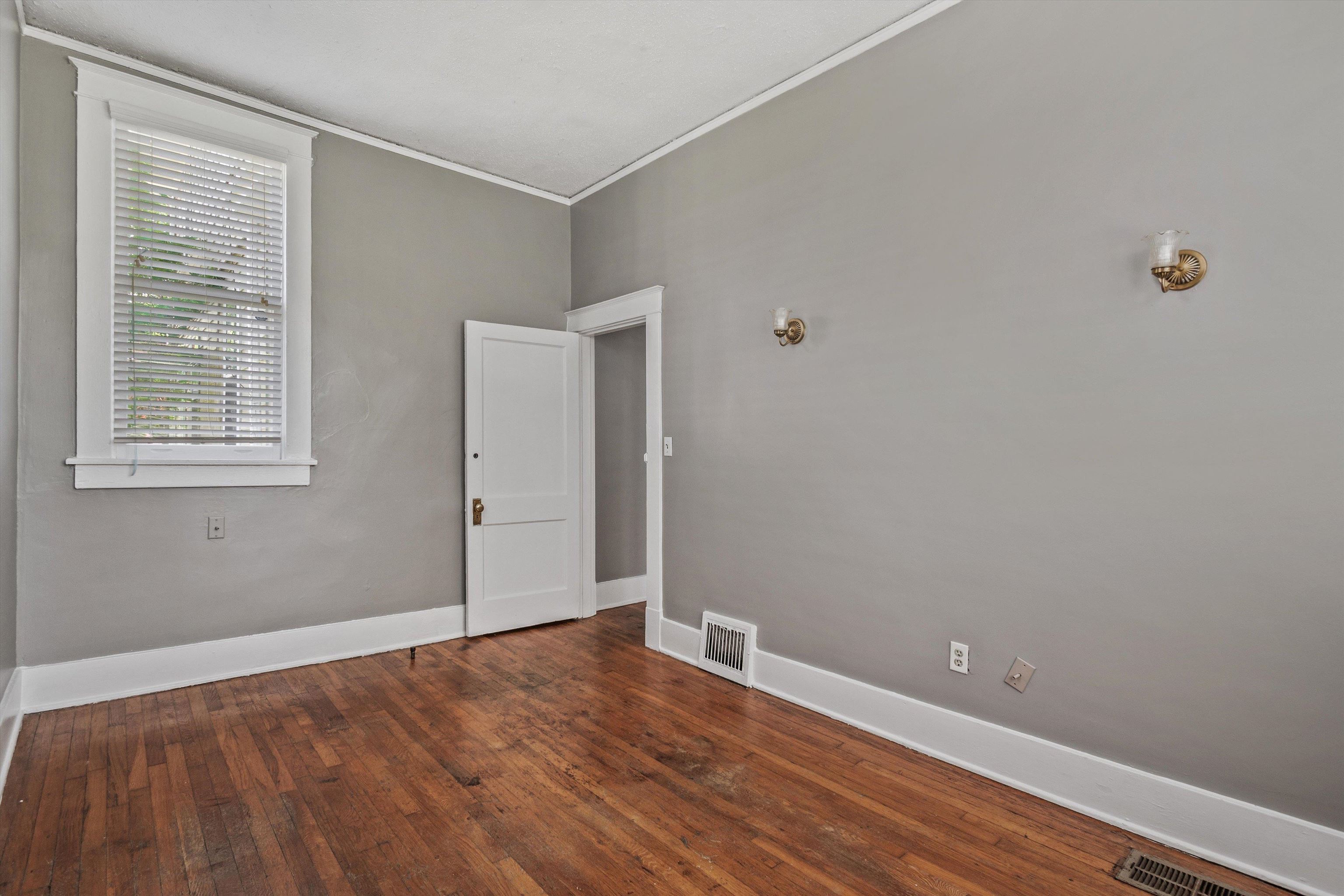 1983 Harbert Avenue Memphis, TN 38104 - Photo 11 of 40 a view of an empty room with wooden floor and a window