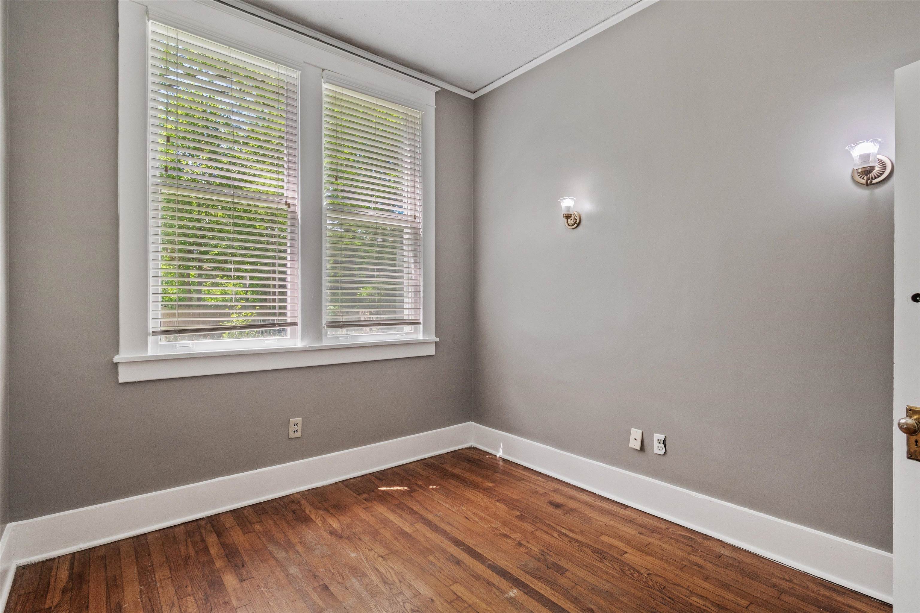 1983 Harbert Avenue Memphis, TN 38104 - Photo 14 of 40 a view of an empty room with wooden floor and a window