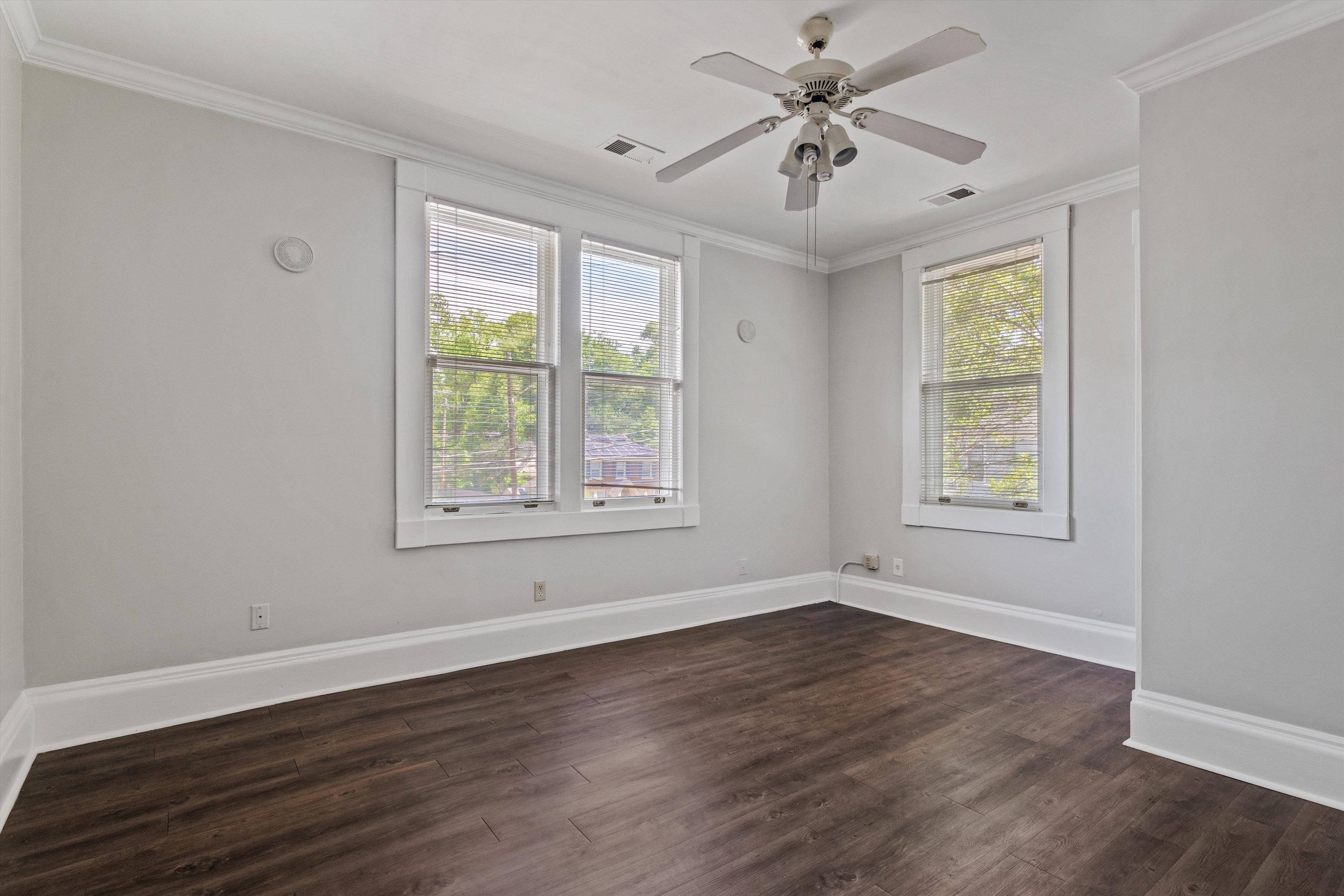 1983 Harbert Avenue Memphis, TN 38104 - Photo 21 of 40 a view of an empty room with wooden floor and a window