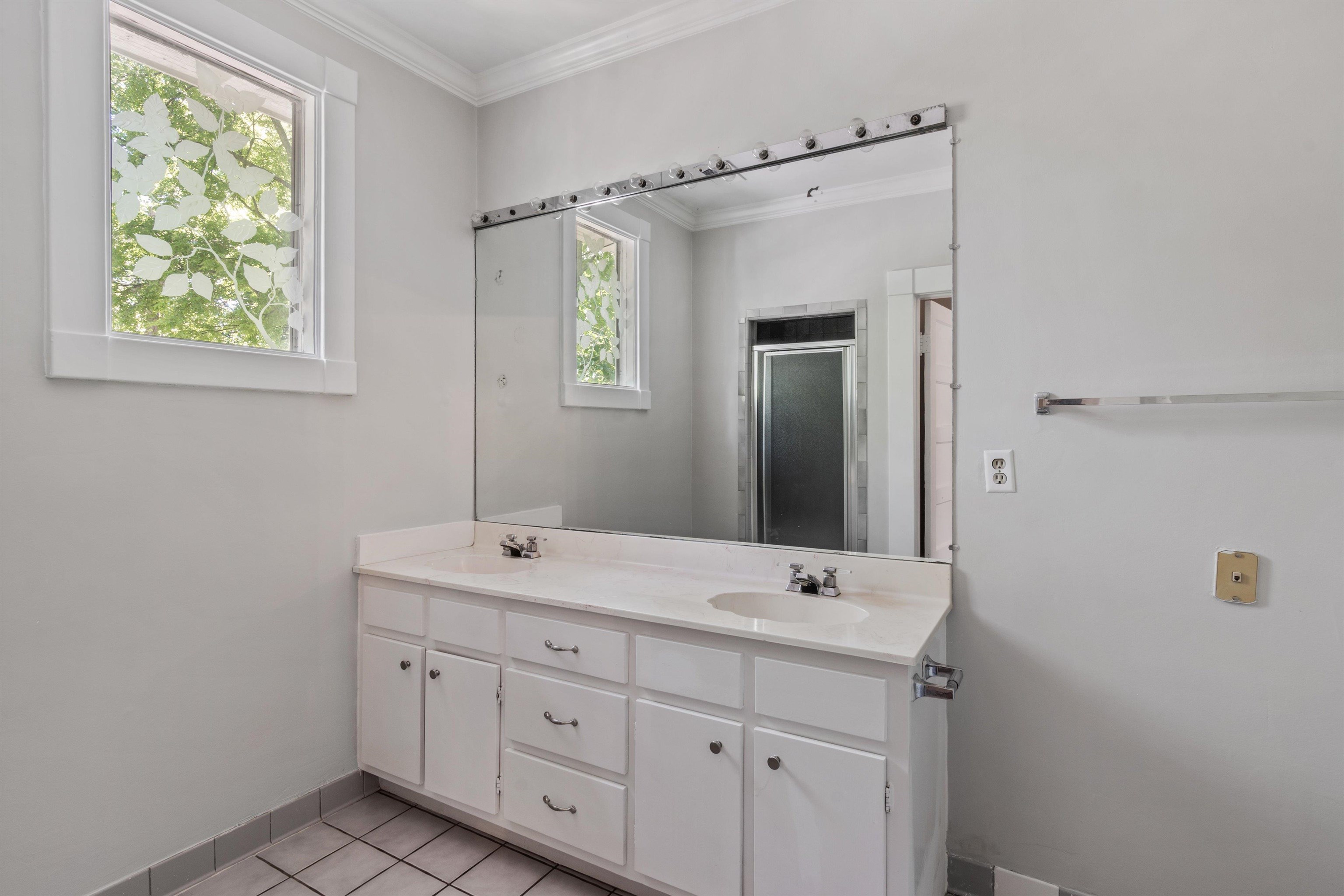 1983 Harbert Avenue Memphis, TN 38104 - Photo 25 of 40 a bathroom with a double vanity sink and mirror