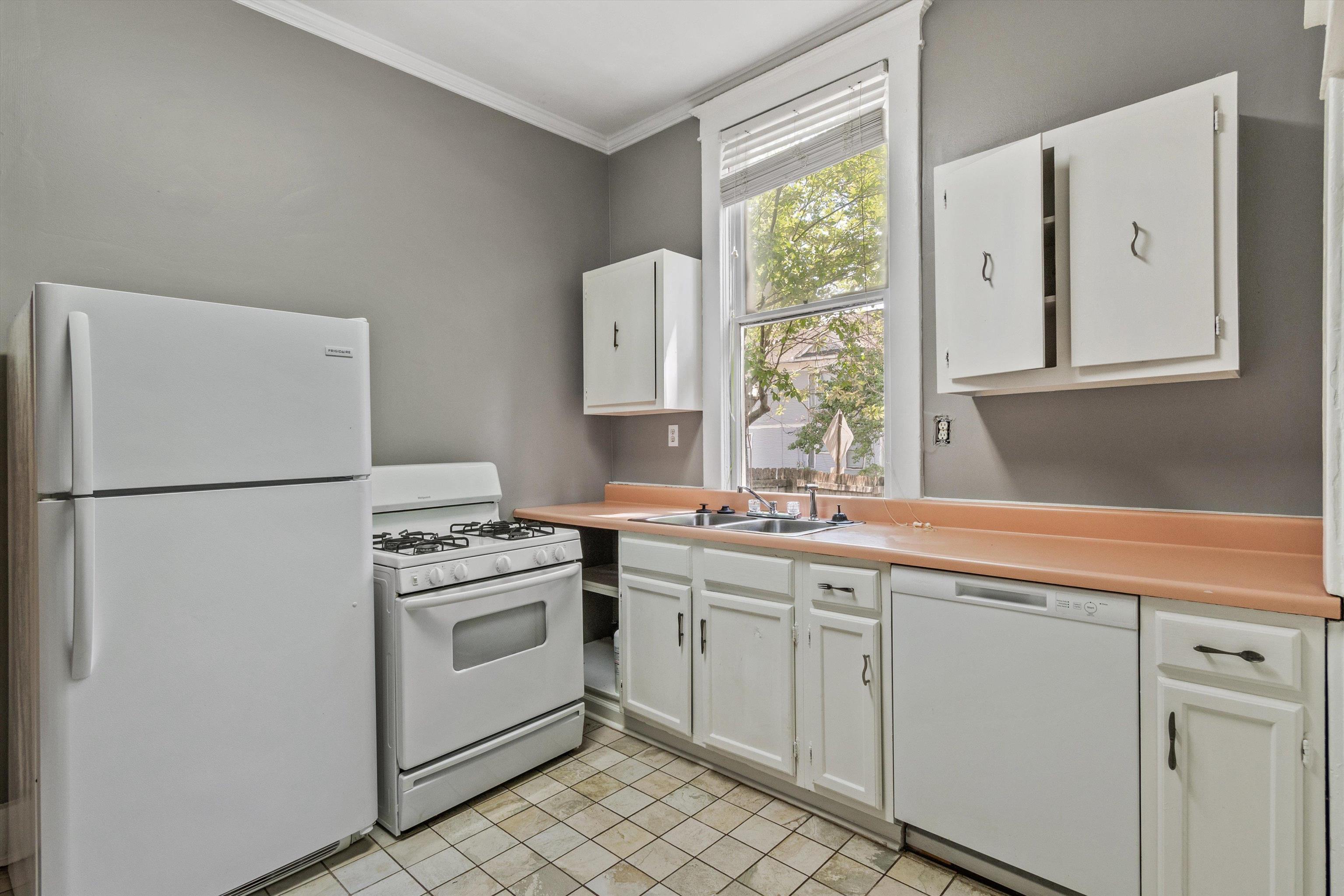 1983 Harbert Avenue Memphis, TN 38104 - Photo 7 of 40 a kitchen with white cabinets and white appliances