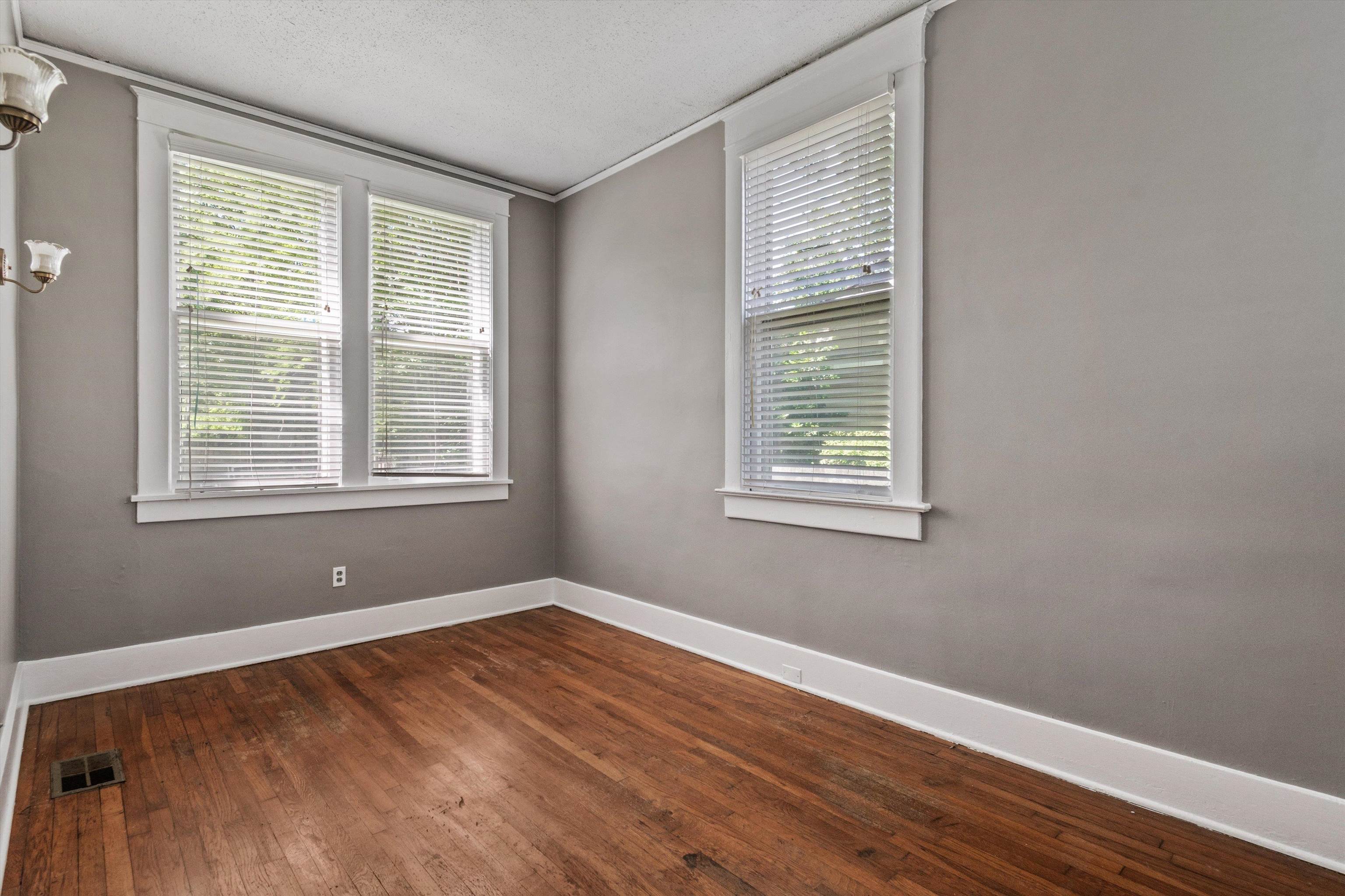 1983 Harbert Avenue Memphis, TN 38104 - Photo 10 of 40 a view of an empty room with wooden floor and a window